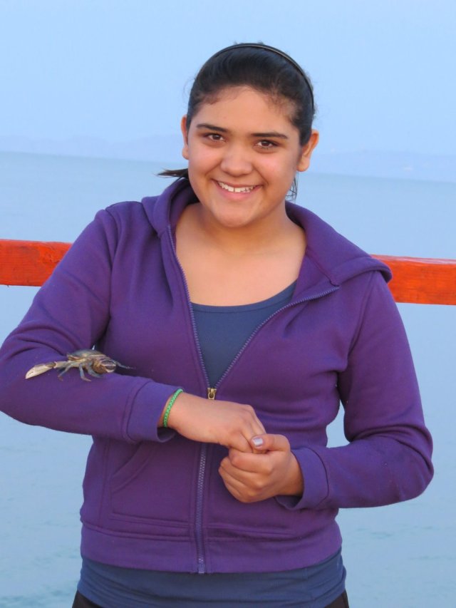 Bravely allowing a crab to walk her arm.